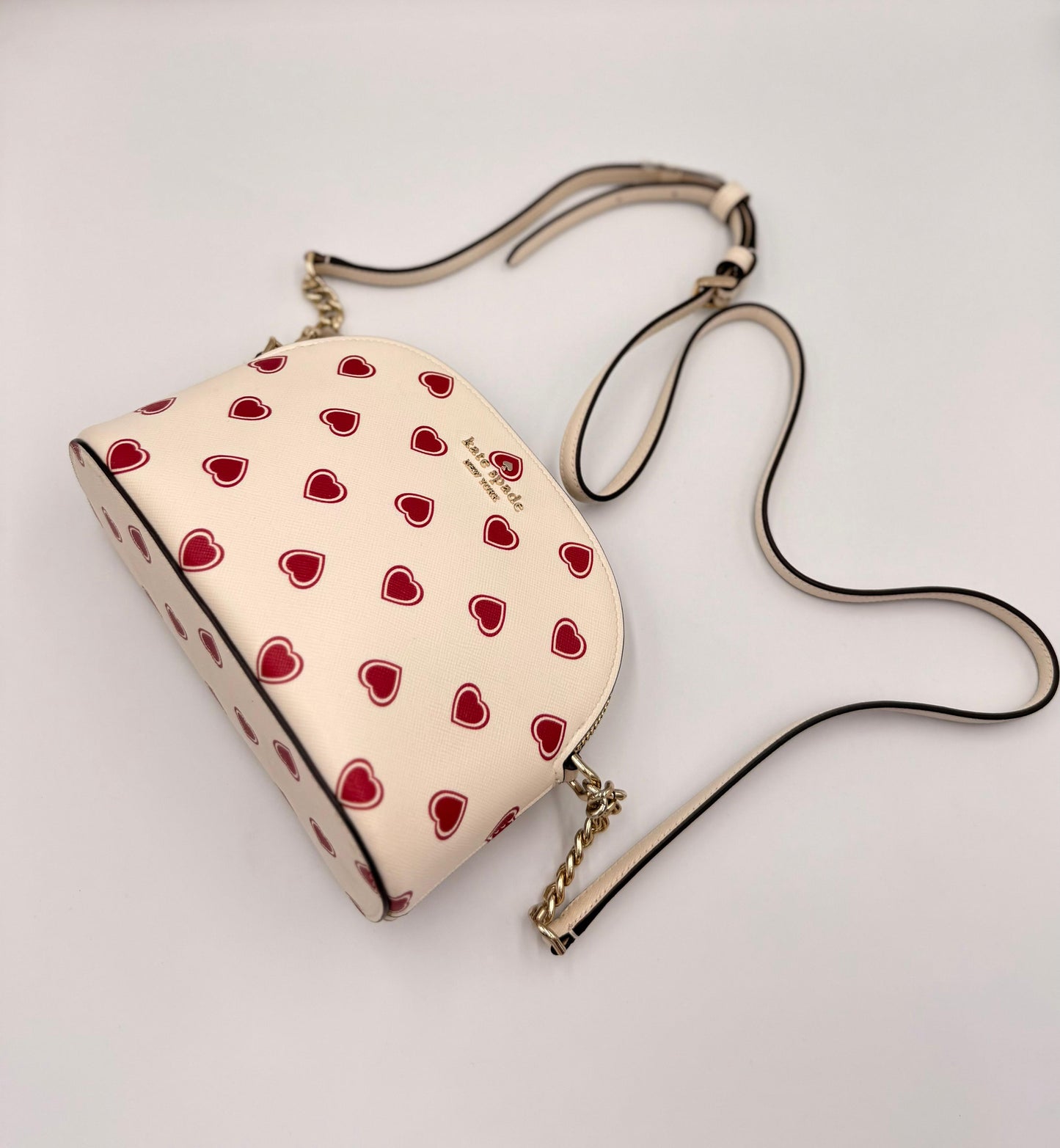 Kate Spade Spencer Small Dome con un diseño de corazones.