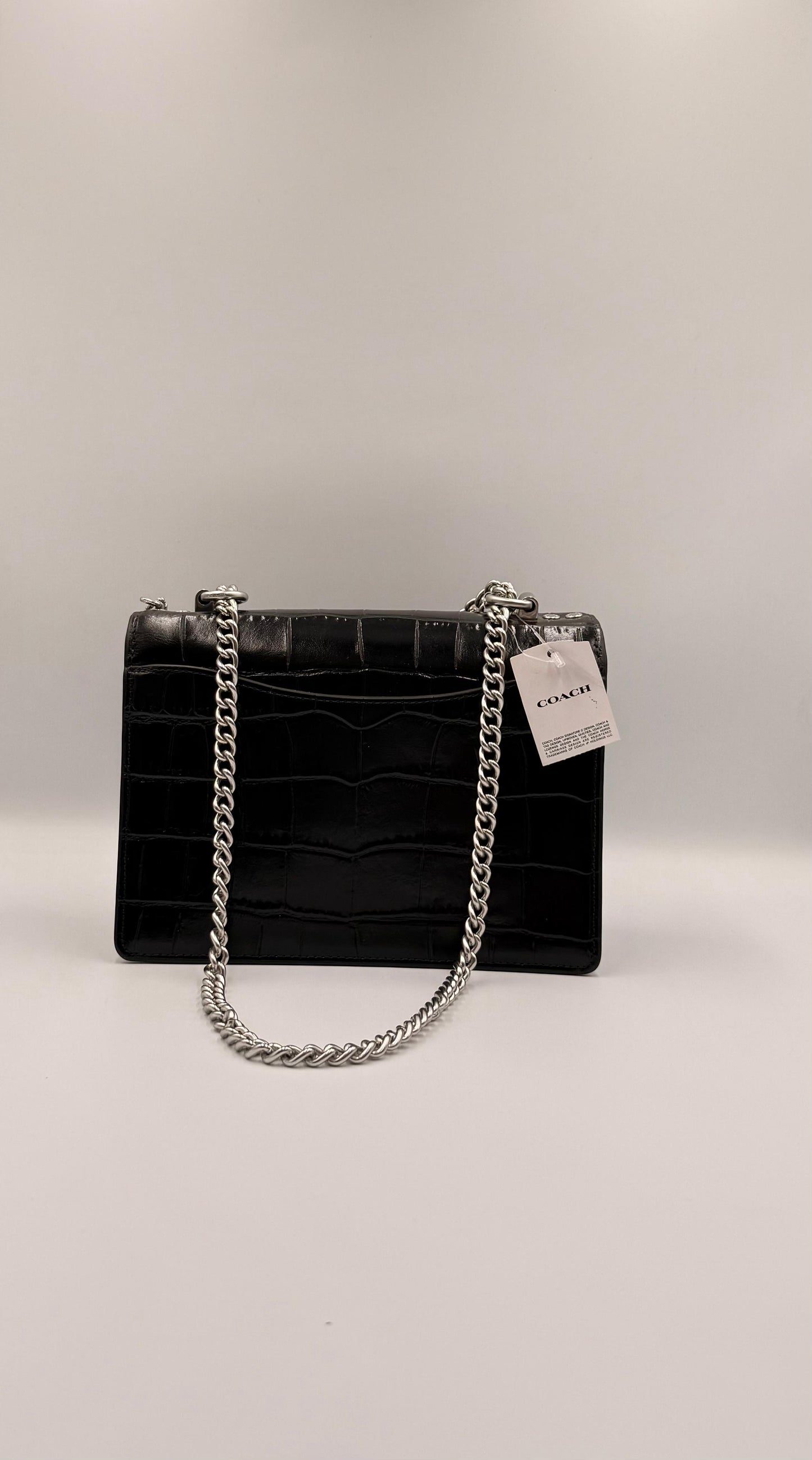 Coach Klare Crossbody en negro con textura de cocodrilo.