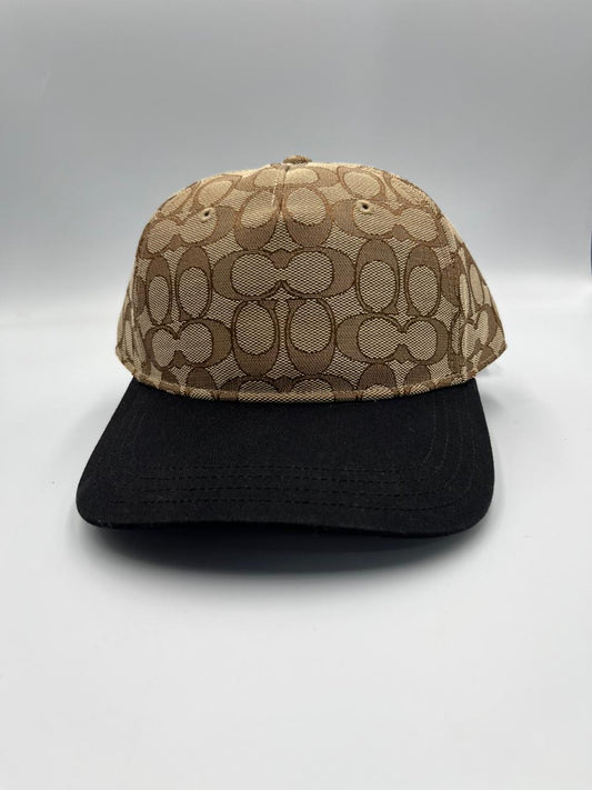 Gorra de béisbol de la marca Coach, modelo "Signature C Jacquard Baseball Hat" en color caqui y negro.